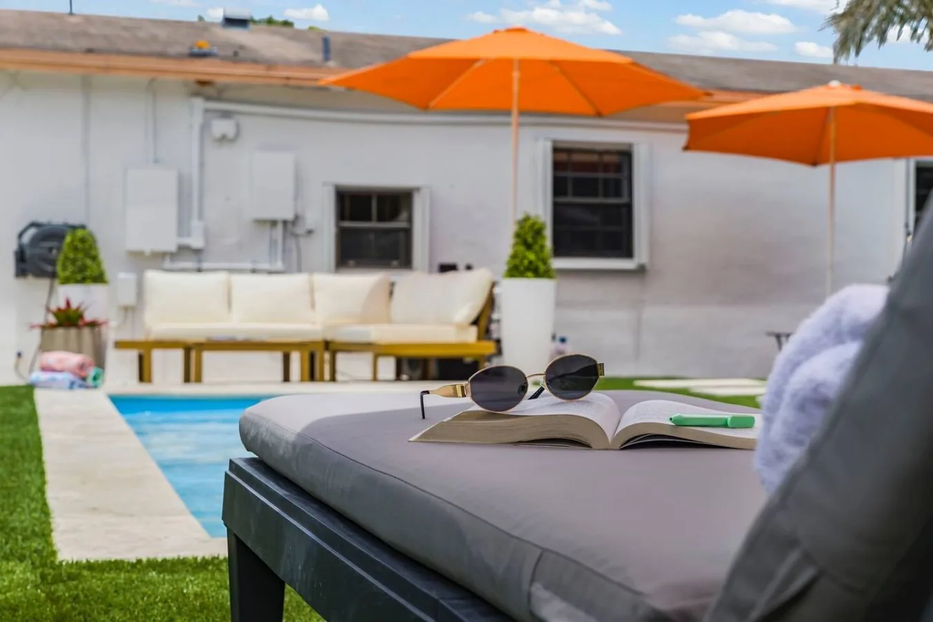 Shaded outdoor patio seating and lounge area next to the pool at Casa Palma vacation rental