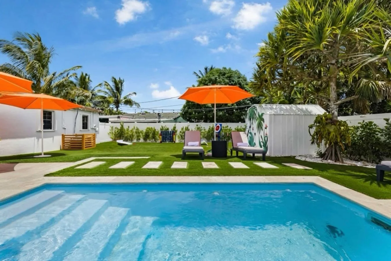 Heated pool and turf lawn with stepping stones in the backyard of Casa Palma in Fort Lauderdale
